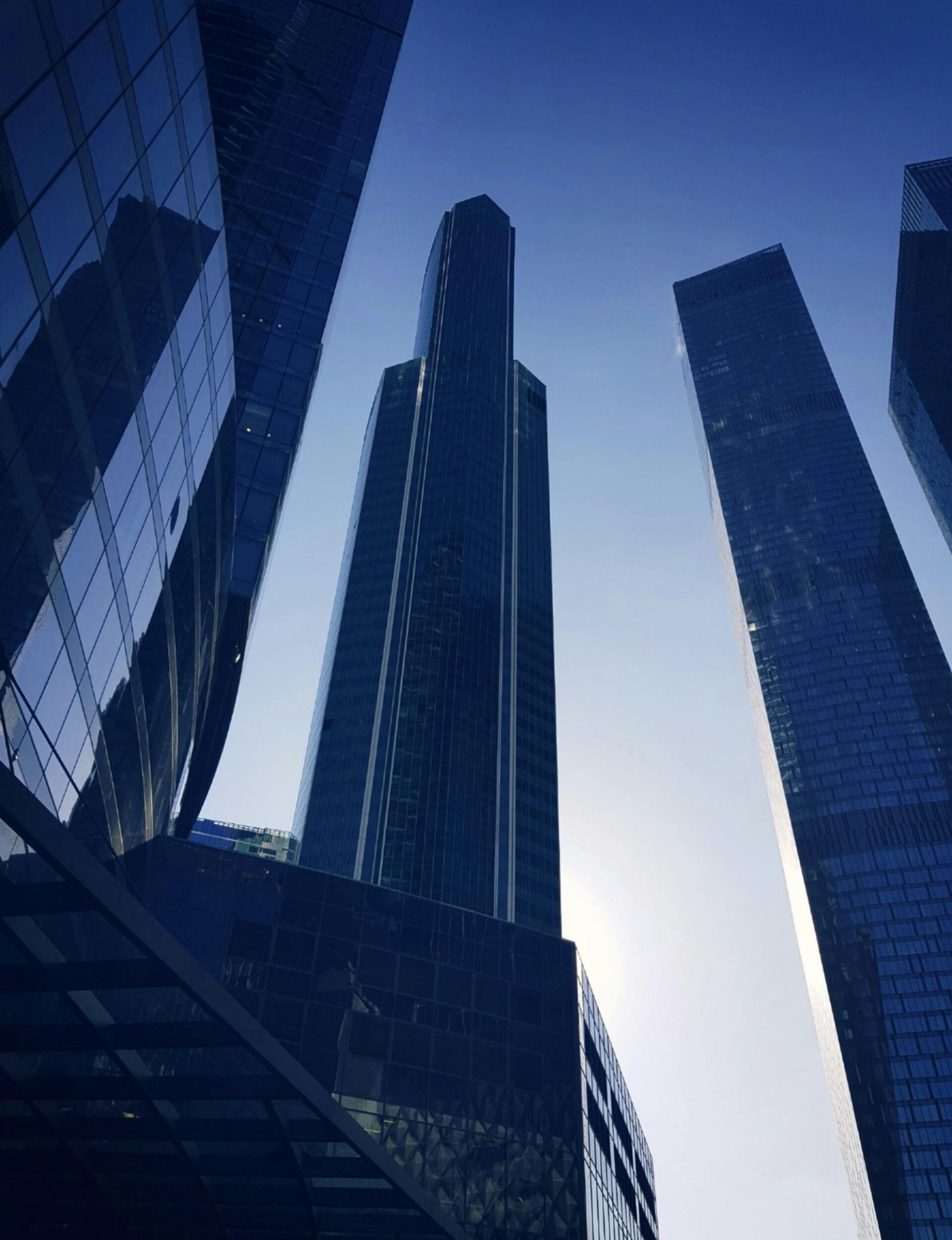 Low angle view of modern skyscrapers in Moscow with a striking morning sun backdrop.